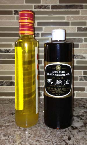 Bottles of cold pressed white and black sesame oils showing light and very dark colors.